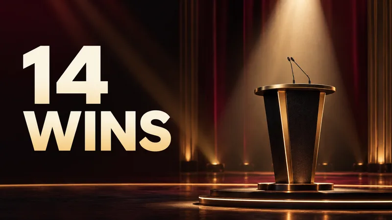 An abstract awards podium under a spotlight beside the large words “14 WINS.”